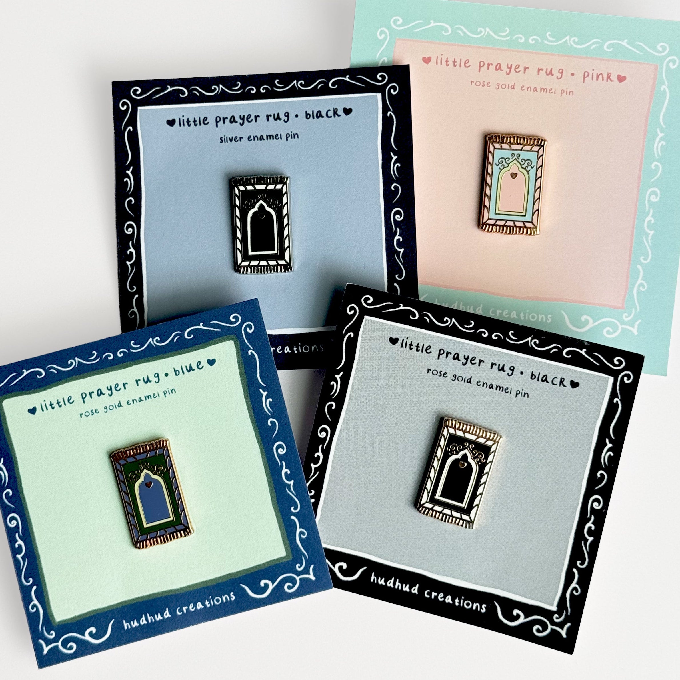 Four prayer rug pins on display with their packaging.